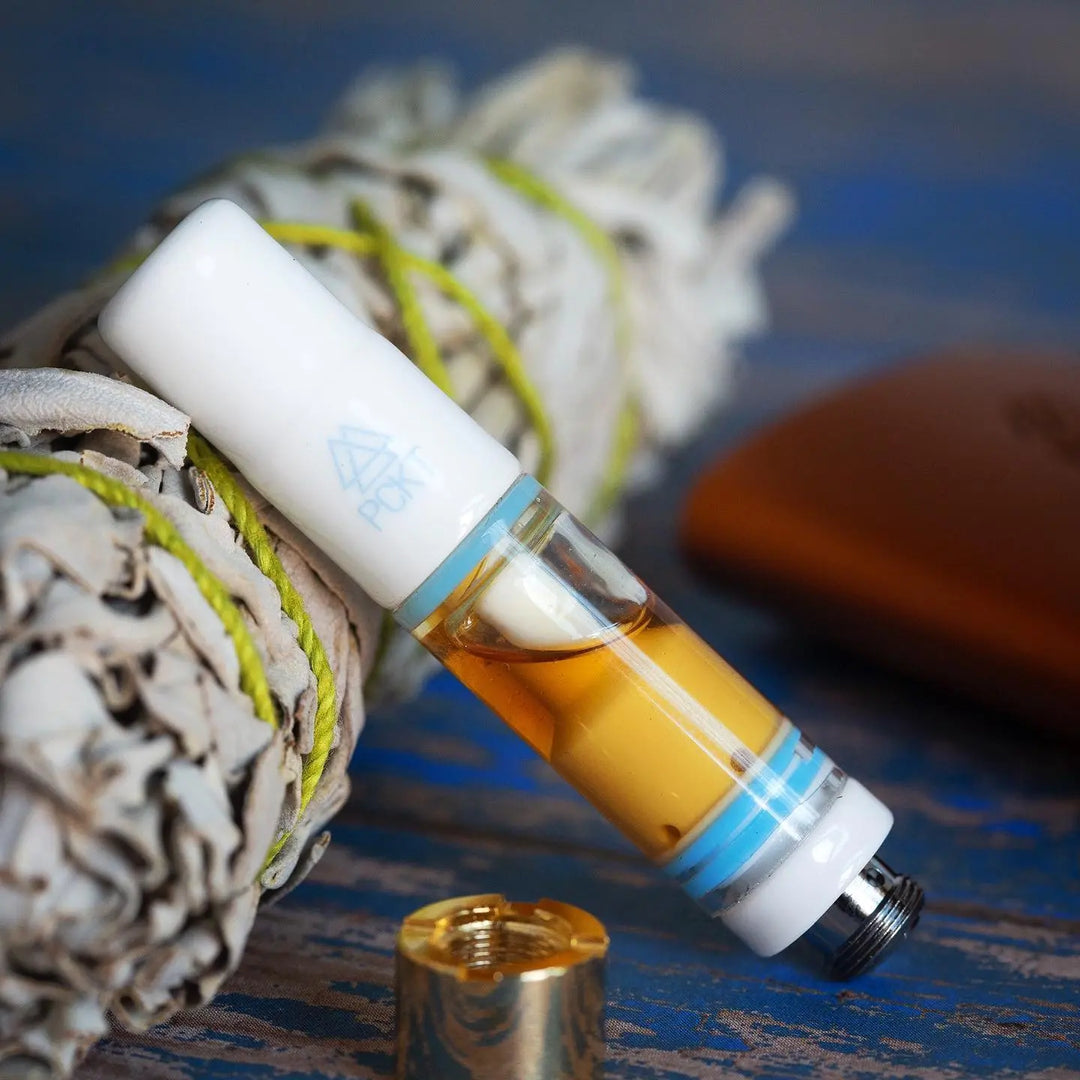 PCKT SPRK Cartridge filled with oil balanced on a bundle of sage