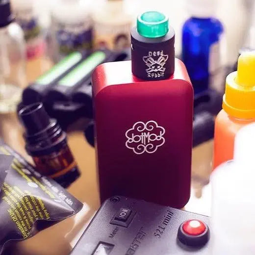 image of a variety of vape accessories surrounding a vape batterie